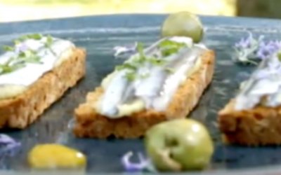 Boquerones marinados en cítricos sobre tostas de pan de tomate y hummus de aceituna Manzanilla